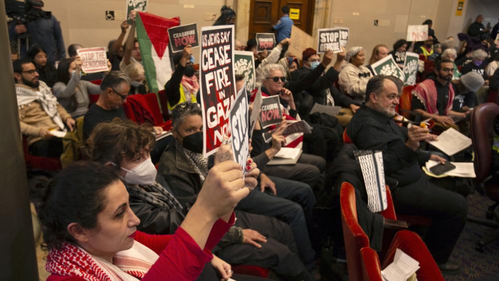 Audience members show their support at a special session of the Oakland City Council for a resolution calling for an immediate cease-fire in Gaza, Monday, Nov. 27, 2023, in Oakland, Calif. (AP Photo/D. Ross Cameron)