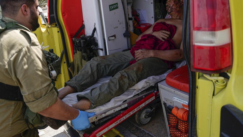 Israeli security forces in Kiryat Shoma, northern Israel, evacuate a wounded Thai man after he was hit by an anti-tank missile fired from Lebanon, in a nearby village on Monday, March 4, 2024. (AP Photo/Ariel Schalit)