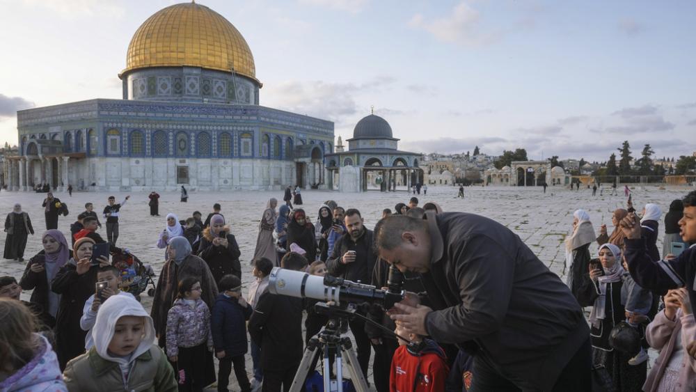 A man observes the moon through a telescope next to the Dome of Rock Mosque at the Al-Aqsa Mosque compound in Jerusalem&#039;s Old City, Sunday, March 10, 2024. (AP Photo/Mahmoud Illean) 