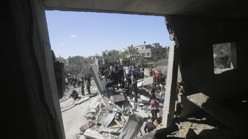 Palestinians look at a residential building destroyed in an Israeli strike in Rafah, Gaza Strip, Tuesday, March 20, 2024. (AP Photo/Hatem Ali)