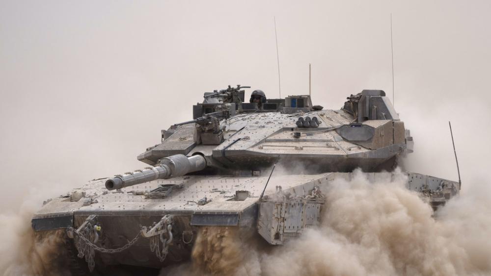 An Israeli soldier moves on the top of a tank near the Israeli-Gaza border, as seen from southern Israel, Tuesday, May 28, 2024. (AP Photo/Leo Correa)