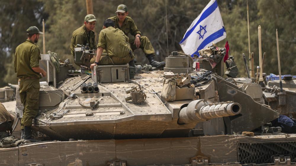 Israeli soldiers work on a tank near the Israeli-Gaza border, in southern Israel, Wednesday, May 29, 2024. (AP Photo/Tsafrir Abayov)