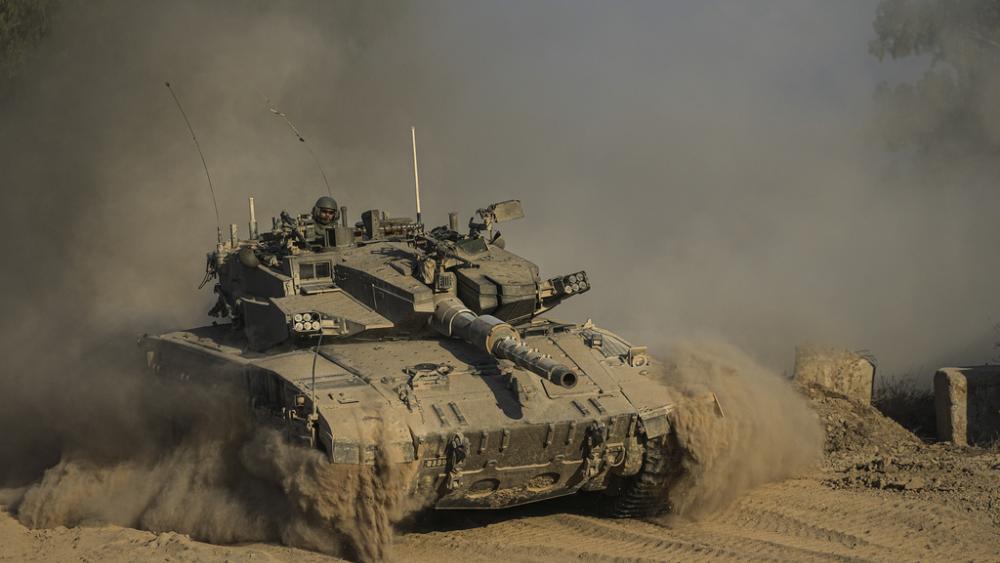 An Israeli soldier moves on the top of a tank near the Israeli-Gaza border, as seen from southern Israel, Sunday, July 14, 2024. (AP Photo/Tsafrir Abayov)