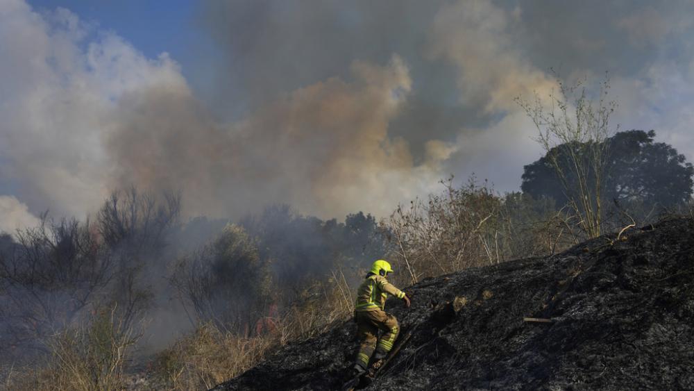 A firefighter works in the area around a fire after the military said it fired interceptors at a missile launched from Yemen that landed in central Israel on Sunday, Sept. 15, 2024. (AP Photo/Ohad Zwigenberg)