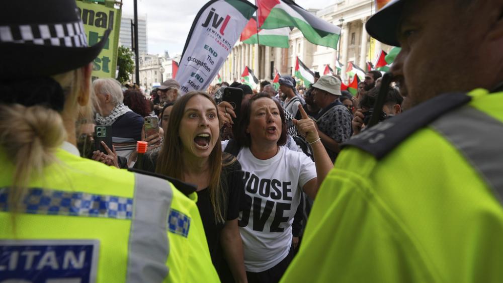 Demonstrators shout and gesture toward a police line during a protest by Palestine Action group in London, Monday, June 23, 2025. (AP Photo/Frank Augstein)