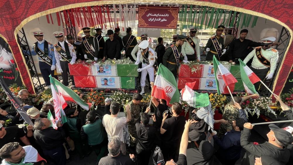 People mourn over the flag-draped coffins of Iranian nuclear scientists who were killed in Israeli strikes, during a funeral ceremony in Tehran. Iran, Saturday, June 28, 2025. (AP Photo/Vahid Salemi)
