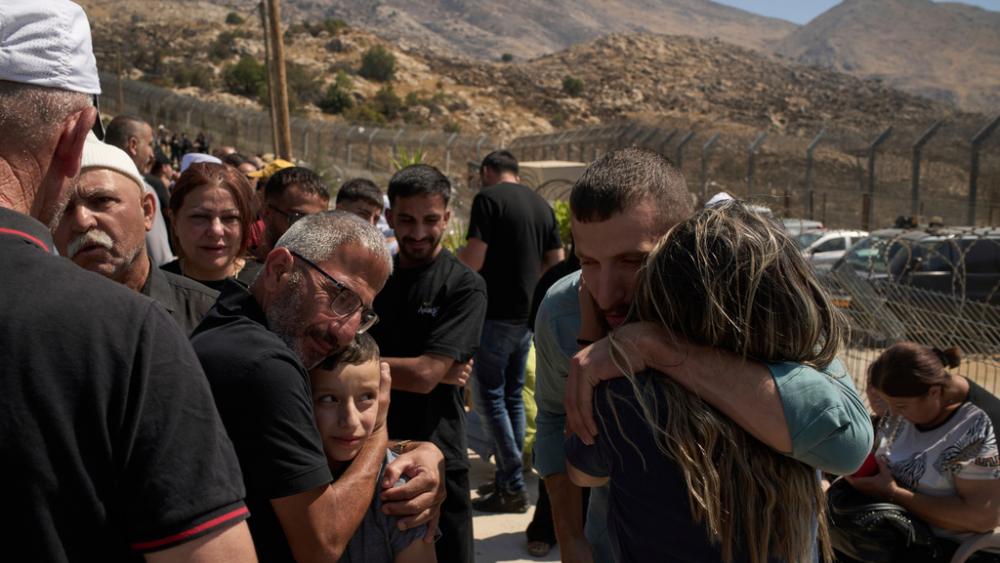 Druze from Syria hug relatives from Israeli Druze community before crossing the Israeli-Syrian border, in the town of Majdal Shams, in the Israeli-controlled Golan Heights, Thursday, July 17, 2025. (AP Photo/Leo Correa)