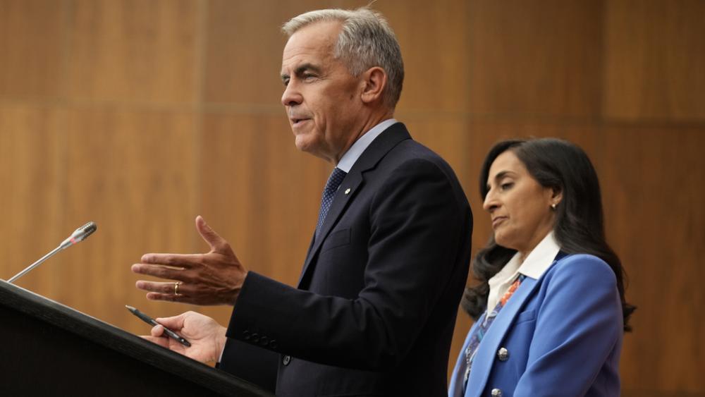 Foreign Affairs Minister Anita Anand looks on as Canada&#039;s Prime Minister Mark Carney speaks with media during a news conference in Ottawa, Ontario, Wednesday, July 30, 2025. (Adrian Wyld/The Canadian Press via AP)