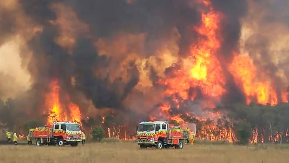 Wildfires burning across Australia&#039;s two most-populous states Tuesday trapped residents of a seaside town in apocalyptic conditions, destroyed many properties and caused fatalities. (Twitter@NSWRFS via AP)