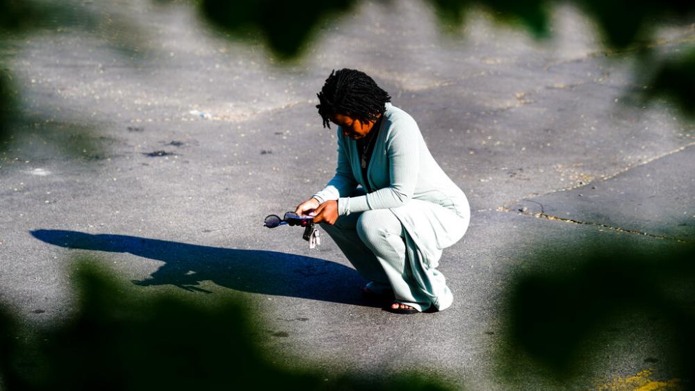 A person pauses outside the scene of a shooting at a supermarket, in Buffalo, N.Y., Sunday, May 15, 2022. (AP Photo/Matt Rourke)