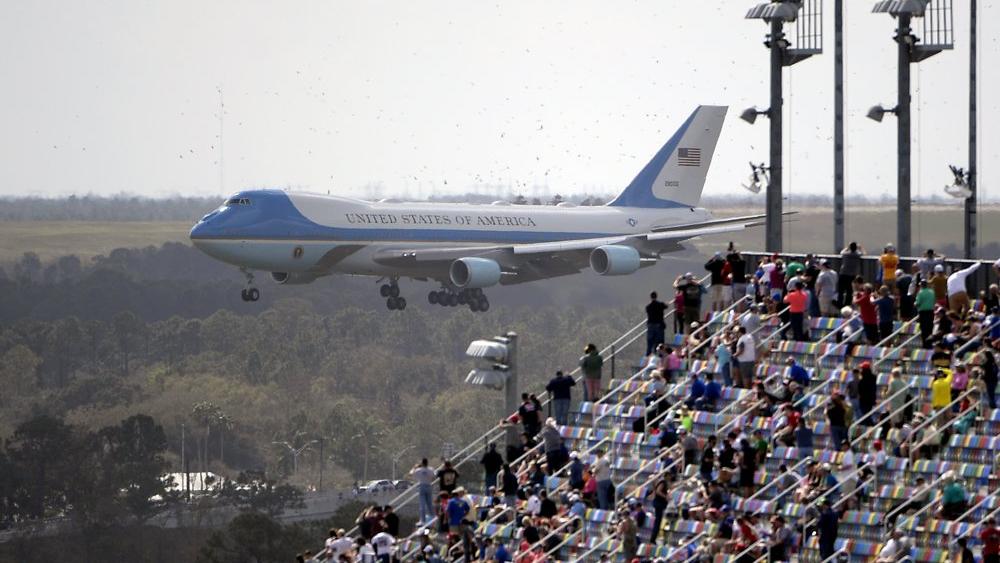 Fans watch from the grandstands as Air Force One, carrying President Donald Trump, prepares to land at Daytona International Airport (AP Photo/Phelan M. Ebenhack)