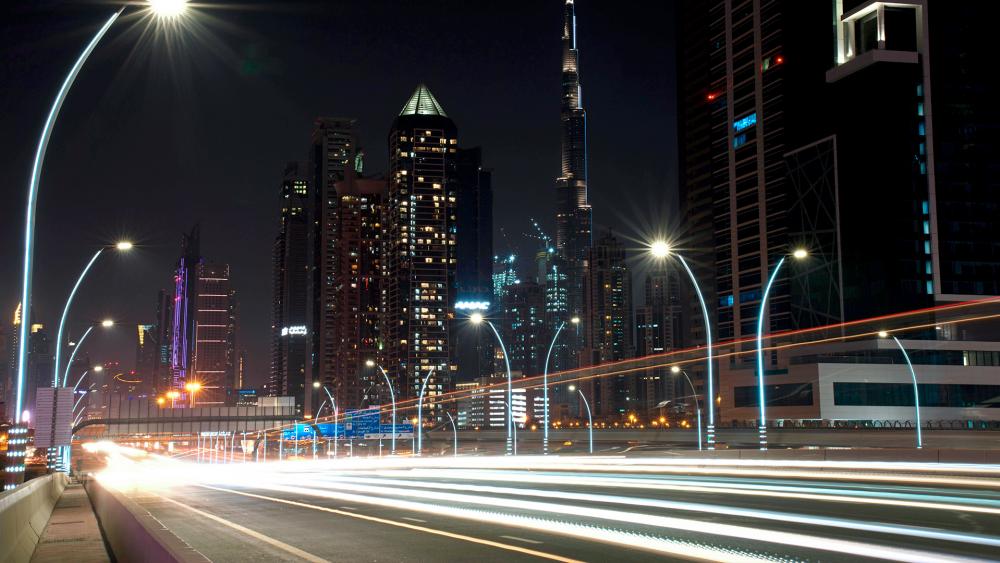 In this photo taken with a slow shutter speed, traffic speeds down the Sheikh Zayed Road in Dubai, United Arab Emirates, Monday, July 6, 2020. (AP Photo/Jon Gambrell)