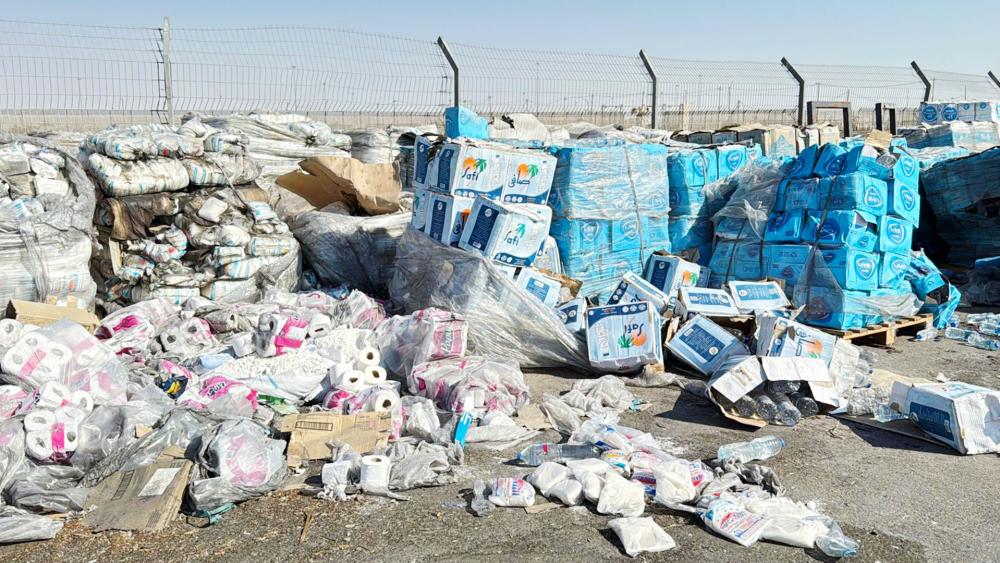 Tons of humanitarian aid and food sit in a parking lot just inside the border fence, but the UN refuses to distribute it. Photo Credit: CBN News. 