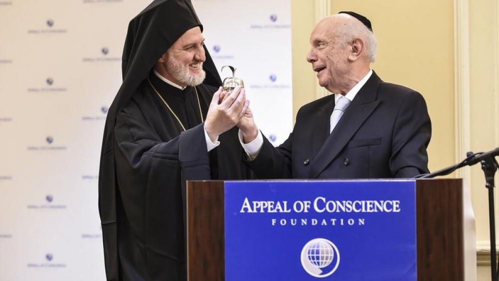 Rabbi Arthur Schneier, senior rabbi of Park East Synagogue, presents a silver apple to welcome Archbishop Elpidophoros, the new leader of the Greek Orthodox Archdiocese of America, to New York, Friday, June 21, 2019.  (Diane Bondareff/AP Image)