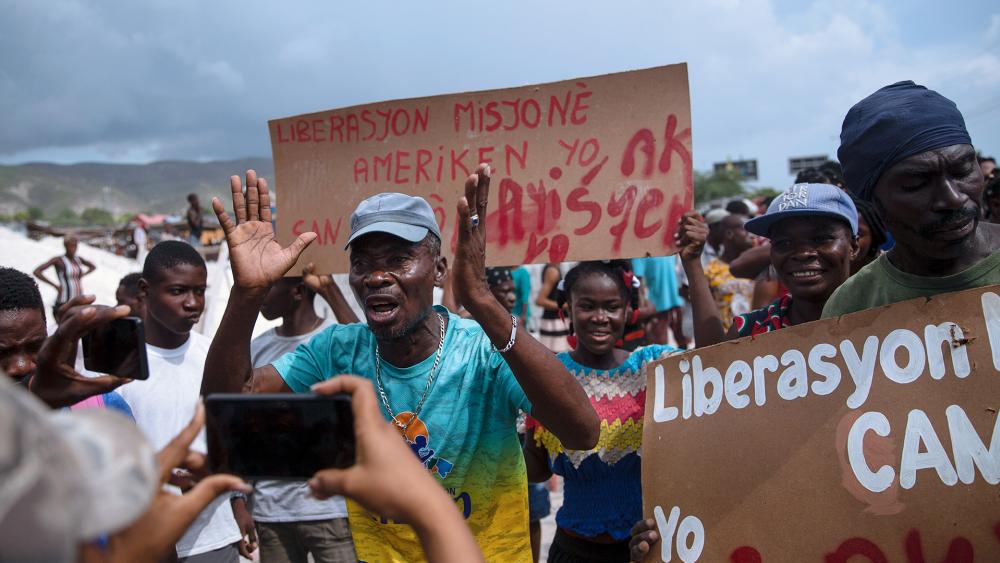 People protest for the release of 17 kidnapped missionaries near the missionaries&#039; headquarters in Titanyen, north of Port-au-Prince, Haiti (AP Photo/Joseph Odelyn)