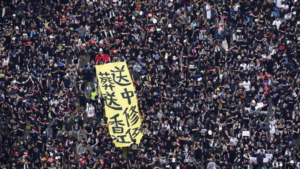 Tens of thousands of protesters carry posters and banners march through the streets as they continue to protest an extradition bill, Sunday, June 16, 2019, in Hong Kong. (Apple Daily via AP)