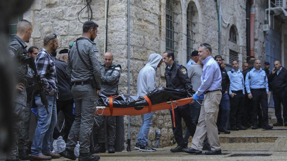 Israeli security personnel and members of Zaka Rescue and Recovery team carry the body of a Palestinian man who was fatally shot by Israeli police after he killed one Israeli and wounded four others in a shooting attack in Jerusalem&#039;s Old City, Sunday, No