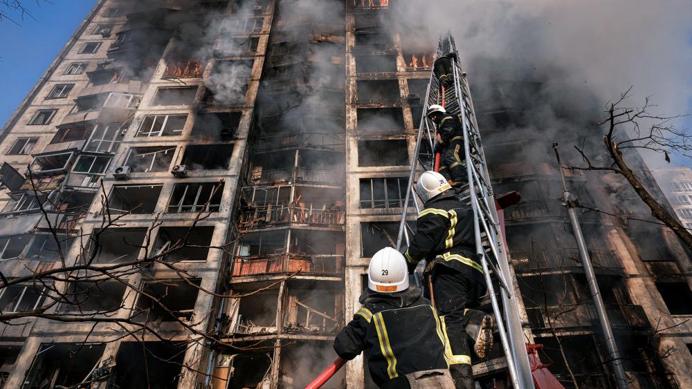 Firefighters climb a ladder while working to extinguish a blaze in a destroyed apartment building after a bombing in a residential area in Kyiv, Ukraine, Tuesday, March 15, 2022 (AP Photo/Vadim Ghirda)