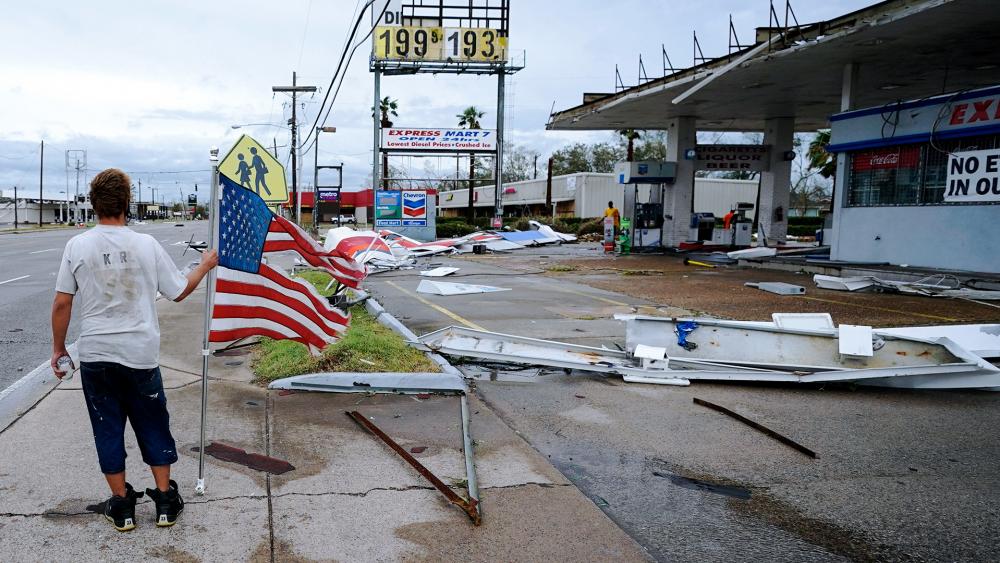 Dustin Amos walks near debris at a gas station on Thursday, Aug. 27, 2020, in Lake Charles, La., after Hurricane Laura moved through the state. (AP Photo/Gerald Herbert)