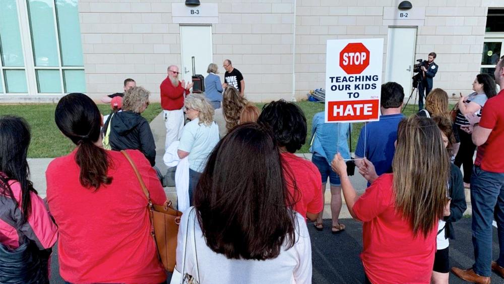 Parents protest the school board&#039;s support for Critical Race Theory with a sign saying: &quot;Stop teaching our kids to hate.&quot; (Image: Tara Mergener, CBN News)