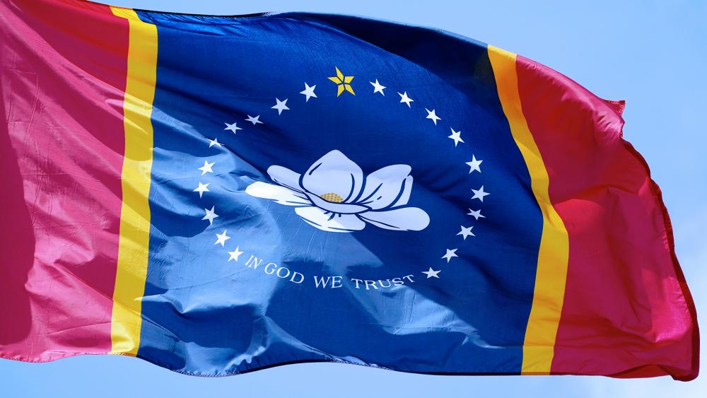 The magnolia centered banner chosen Sept. 2, 2020 by the Mississippi State Flag Commission flies outside the Old State Capitol Museum in downtown Jackson, Miss. That design will go on the Nov. ballot for voters consideration (AP Photo/Rogelio V. Solis)