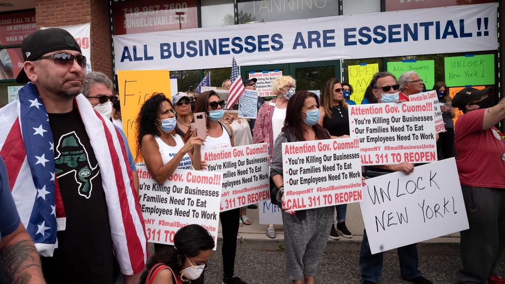 A crowd of supporters shows up for Bobby Catone, the owner of a Staten Island tanning salon, May 28, 2020, in NY. He opened the salon in defiance of a law requiring non-essential businesses to remain closed (AP Photo/Mark Lennihan)