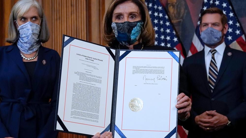 House Speaker Nancy Pelosi (D-CA) displays the article of impeachment that she signed against President Donald Trump, Wednesday, Jan. 13, 2021. (AP Photo/Alex Brandon)