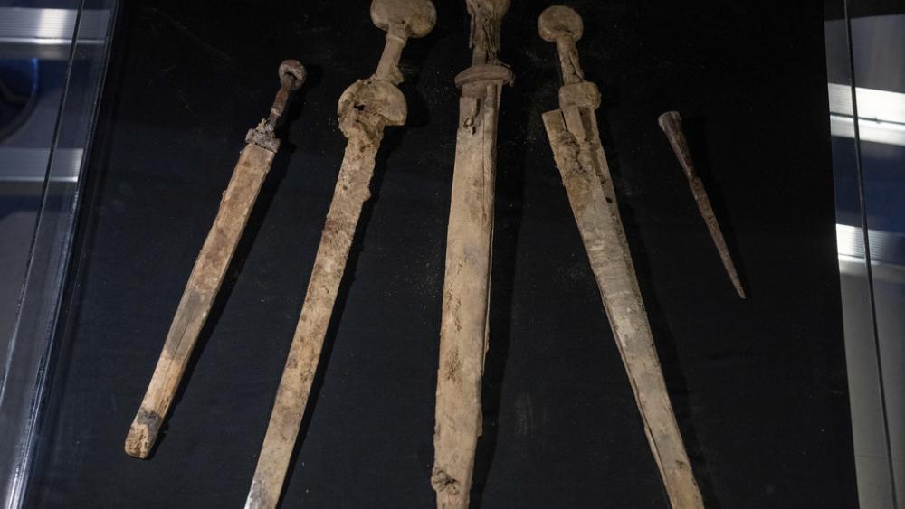 Israeli archaeologists show four Roman-era swords and a javelin head found during a recent excavation in a cave near the Dead Sea, in Jerusalem, Sep. 6, 2023. (AP Photo/Ohad Zwigenberg)