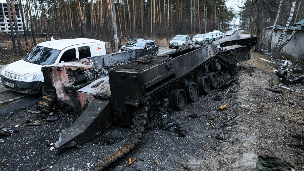 Cars drive past a destroyed Russian tank as a convoy of vehicles evacuating civilians leaves Irpin, on the outskirts of Kyiv, Ukraine. (AP Photo/Vadim Ghirda)