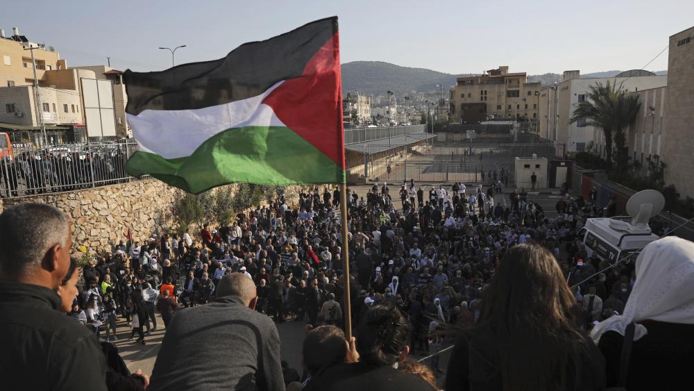 A Palestinian flag flies over the annual Land Day rally in the Arab city of Arraba, northern Israel, Tuesday, March 30, 2021. (AP Photo/Mahmoud Illean)