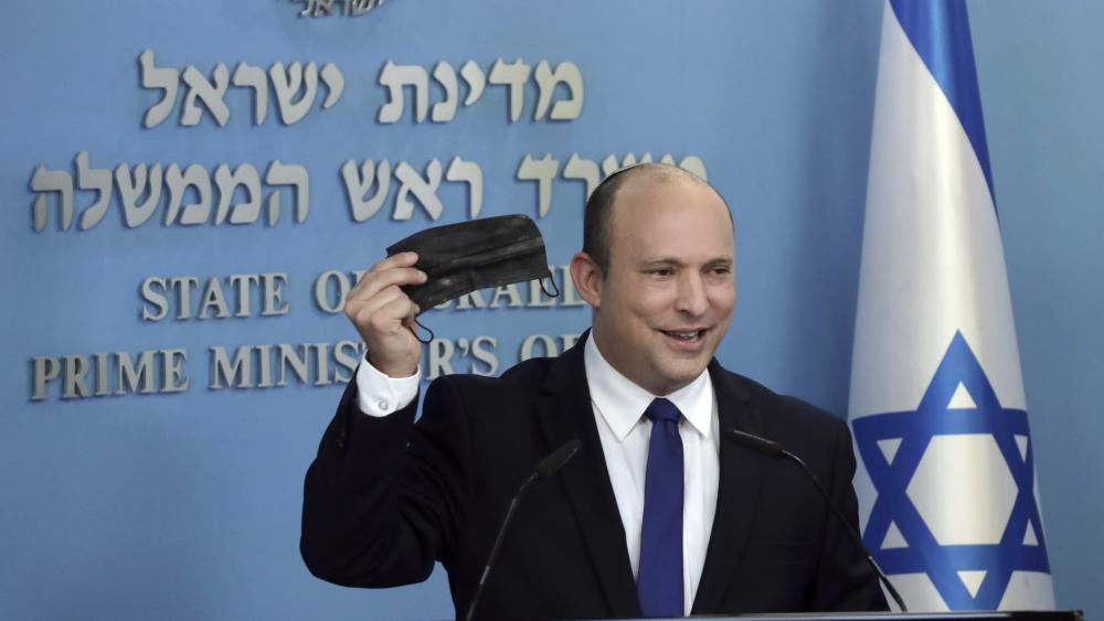 Israeli Prime Minister Naftali Bennett holds up a face mask as he delivers a statement on the coronavirus situation, in Jerusalem Wednesday, July 14, 2021.  (AP Photo/Maya Alleruzzo)