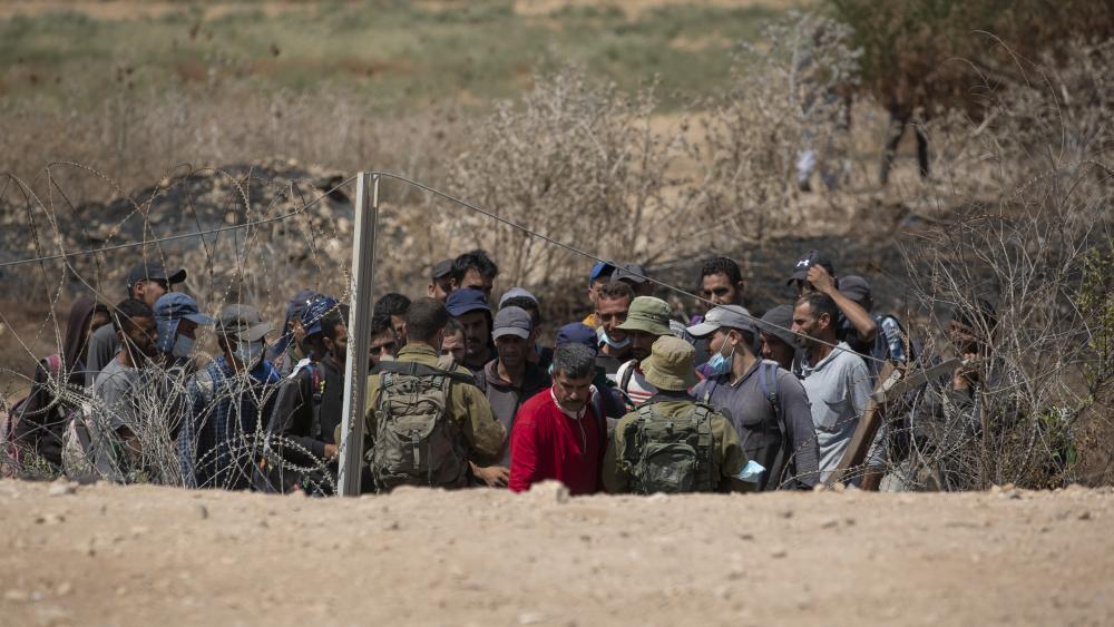 Israeli troops carry out checks on Palestinian laborers returning home after a days work in Israel who are trying to cross through a damaged section of the Israeli separation fence, in the West Bank village of Jalameh, near Jenin, Monday, Sept. 6 (AP)