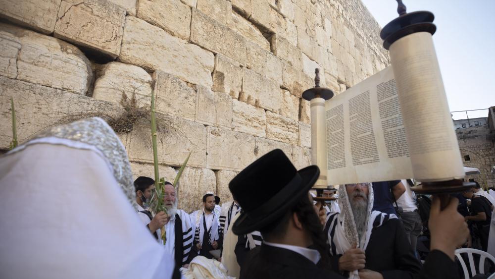 Ultra-Orthodox Jewish men pray during the Jewish holiday of Sukkot at the Western Wall, the holiest site where Jews can pray in the Old City of Jerusalem, Wednesday, Sept. 22, 2021. (AP Photo/Sebastian Scheiner)