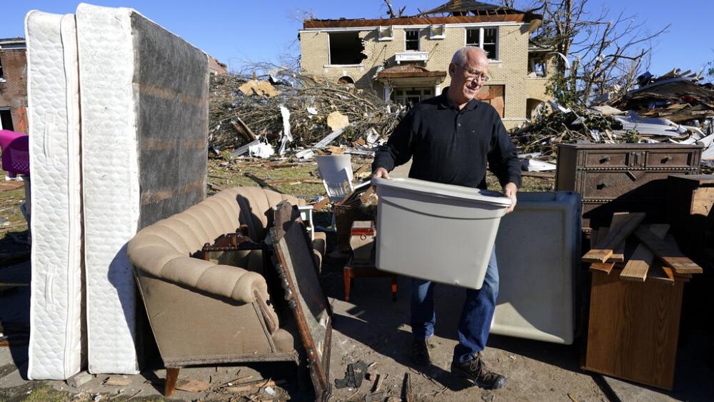 Sam Willett helps to salvage items from a friends' home Sunday, Dec. 12, 2021, in Mayfield, Ky. Tornadoes and severe weather caused catastrophic damage across several states Friday, killing multiple people overnight. (AP Photo/Mark Humphrey)