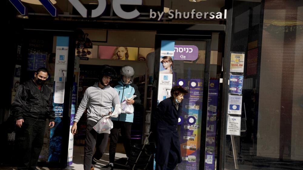 Delivery drivers from the Wolt app leave a pharmacy with rapid antigen tests for the coronavirus for delivery to customers in Tel Aviv, Israel, Monday, Jan. 10, 2022. (AP Photo/Maya Alleruzzo)