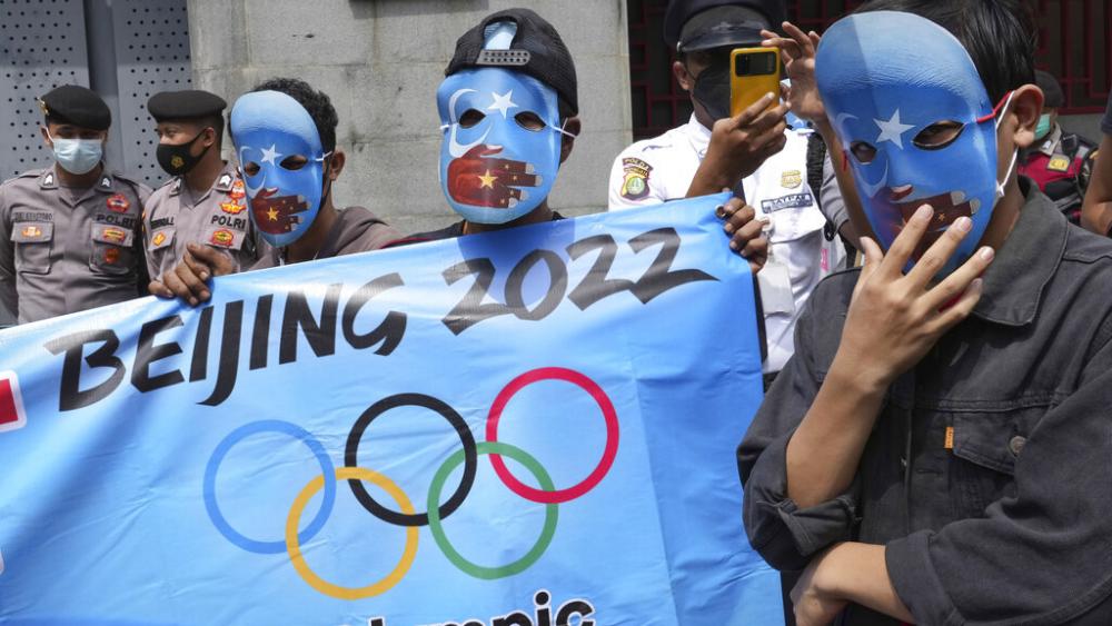 Student activists wear masks with the colors of the pro-independence East Turkistan flag during a rally to protest the Beijing 2022 Winter Olympic Games, outside the Chinese Embassy in Jakarta, Indonesia, Friday, Jan. 14, 2022. AP Photo. 