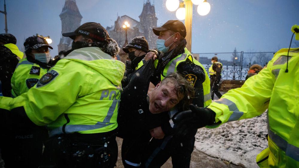 A man is arrested by police as protesters and supporters gather as a protest against COVID-19 measures.  (Cole Burston/The Canadian Press via AP)