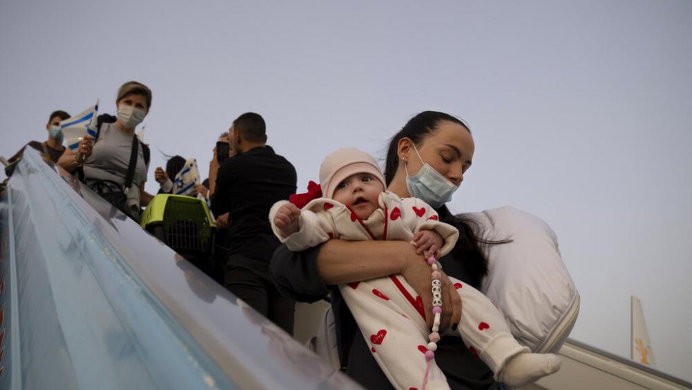 A Ukranian woman carries her baby as they disembark from an airplane on arrival to Israel at Ben Gurion Airport, Sunday, March 6, 2022.(AP Photo/Maya Alleruzzo)