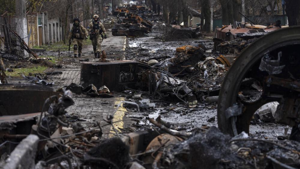 Soldiers walk amid destroyed Russian tanks in Bucha, in the outskirts of Kyiv, Ukraine, Sunday, April 3, 2022. (AP Photo/Rodrigo Abd)