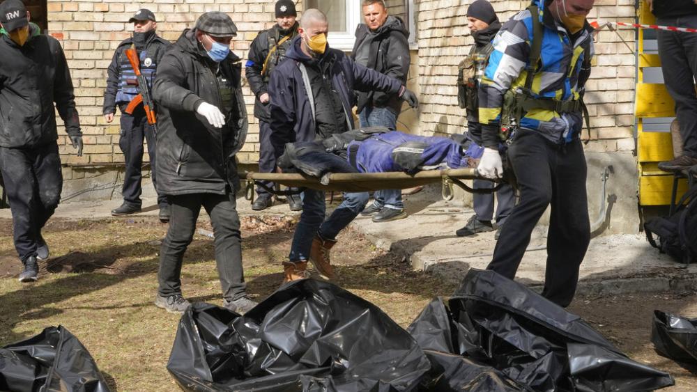 Volunteers collect bodies of murdered civilians, in Bucha, close to Kyiv, Ukraine, Monday, April 4, 2022. (AP Photo)