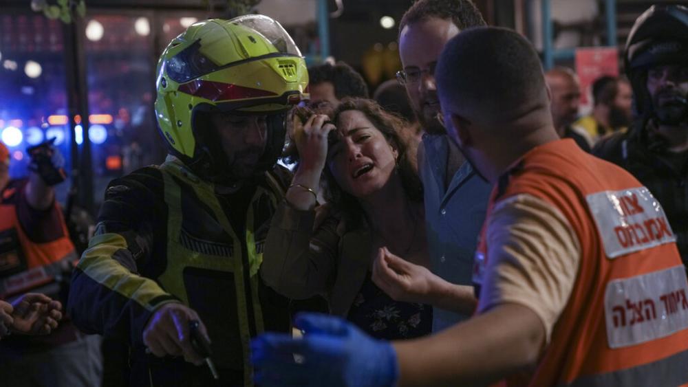 A woman reacts at the scene of a shooting attack In Tel Aviv, Israel, Thursday, April 7, 2022. (AP Photo)