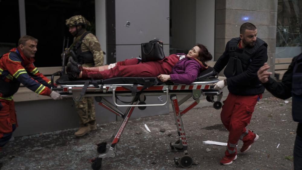 A woman is taken to an ambulance after being injured in a Russian bombardment in Kharkiv, Ukraine, Sunday, April 17, 2022. (AP Photo/Felipe Dana)
