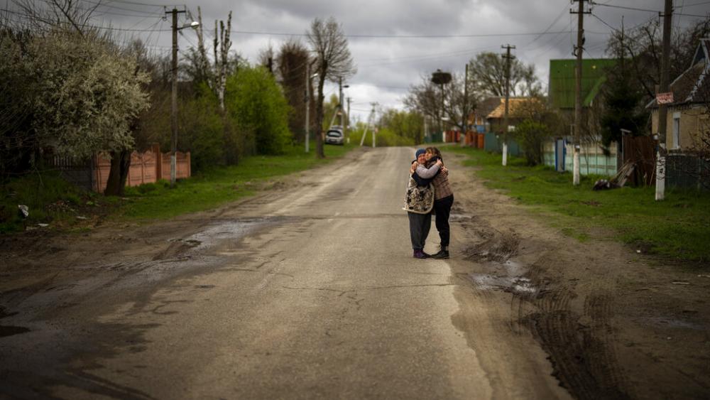 Tetyana Boikiv, 52, right, meets and hugs her neighbour Svitlana Pryimachenko, 48, during a funeral service for her husband, Mykola Moroz, 47, at the Ozera village, near Bucha, Ukraine on Tuesday, April 26, 2022. (AP Photo)