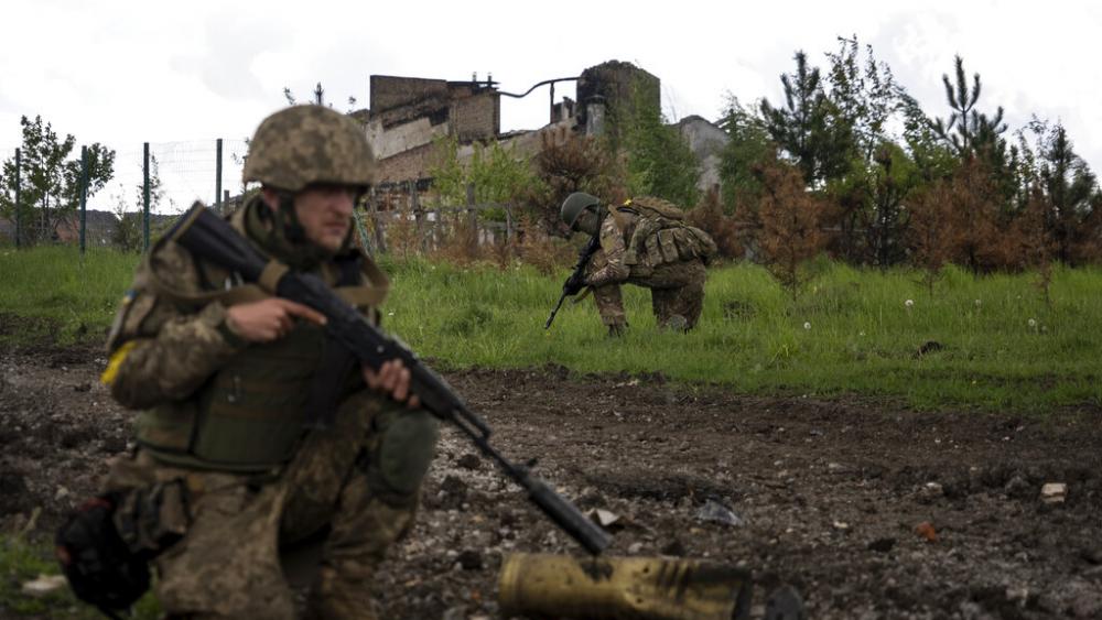 Ukrainian servicemen squat during a patrol in a recently retaken village, north of Kharkiv, east Ukraine, Sunday, May 15, 2022. (AP Photo/Mstyslav Chernov)