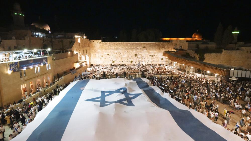 Members of Jewish youth movements unfurl a giant Israeli flag on the eve of Jerusalem Day. (AP Photo)