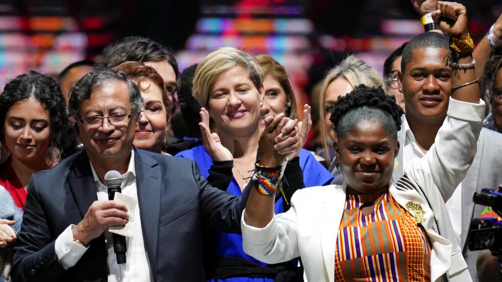 Former rebel Gustavo Petro, left, his wife Veronica Alcocer, back center, and his running mate Francia Marquez, celebrate before supporters after winning a runoff presidential election in Bogota, Colombia, Sunday, June 19, 2022. (AP Photo/Fernando Vergara