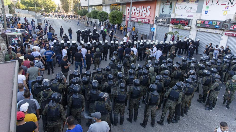 Palestinian riot police and security officers in plainclothes clash with demonstrators following a rally protesting the death of Palestinian Authority outspoken critic Nizar Banat, in the West Bank city of Ramallah, Saturday, June 26, 2021. (AP Photo)