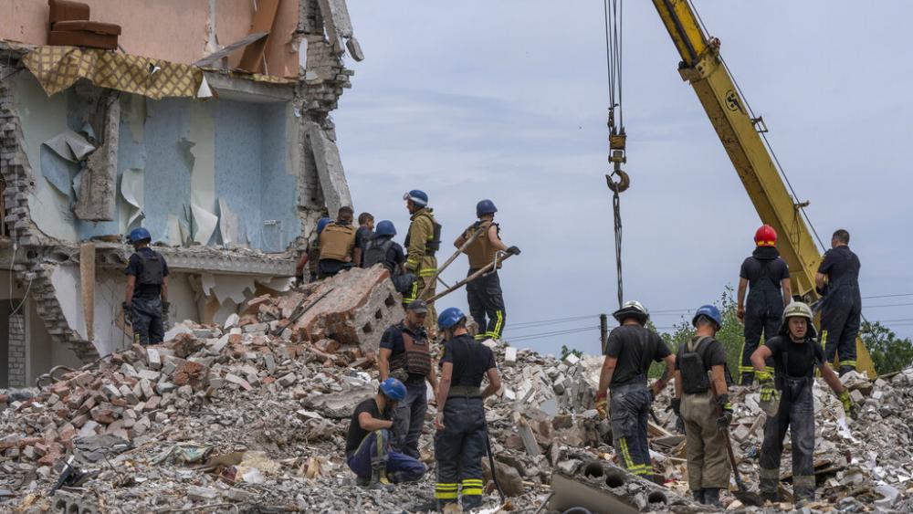 Rescue workers sift through rubble at the scene in the after math of a Russian rocket that hit an apartment residential block, in Chasiv Yar, Donetsk region, eastern Ukraine, Sunday, July 10, 2022. (AP Photo/Nariman El-Mofty)