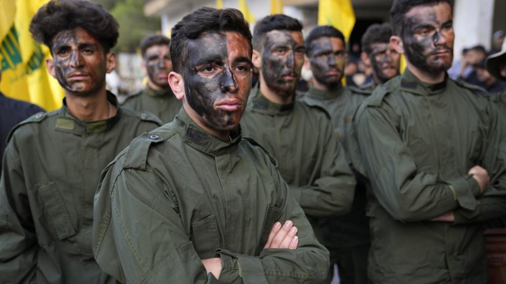 Hezbollah fighters attend the funeral procession of their two comrades who were killed by Israeli shelling, in Kherbet Selem village, south Lebanon, Tuesday, Oct. 10, 2023. (AP Photo/Hussein Malla)