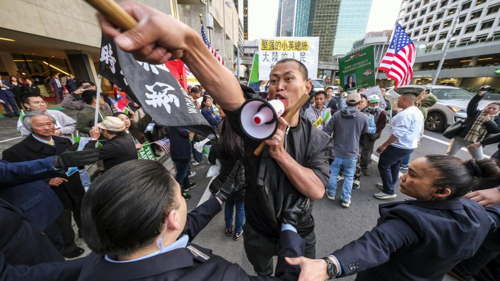 A supporter of Taiwan, center, confronts protesters opposed to Taiwanese independence outside a hotel where Taiwanese President Tsai Ing-wen is expected to arrive in Los Angeles, Tuesday, April 4, 2023. (AP Photo/Ringo H.W. Chiu)